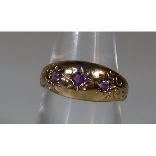 264 - 9ct gold three stone dress ring, set with three small probably amethyst stones. 3.2g approx.
(B.P. 2... 