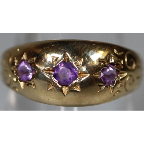 264 - 9ct gold three stone dress ring, set with three small probably amethyst stones. 3.2g approx.
(B.P. 2... 