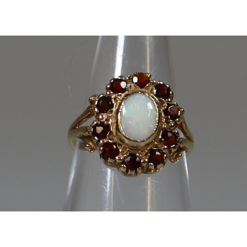 272 - 9ct gold opal and garnet oval-shaped dress ring with split shoulders. 1.5g approx.
(B.P. 21% + VAT)