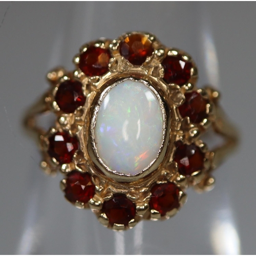 272 - 9ct gold opal and garnet oval-shaped dress ring with split shoulders. 1.5g approx.
(B.P. 21% + VAT)