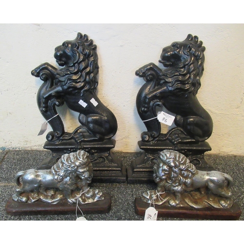 86 - Pair of white metal doorstops in the form of handed lions, together with two black cast metal doorst... 