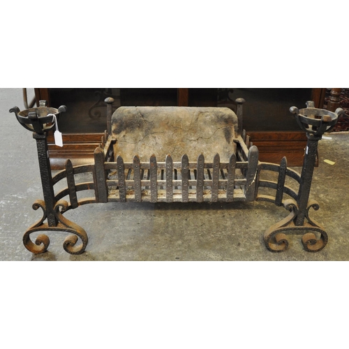 492 - Medieval style wrought iron fire basket with incorporated scrolled andirons and candle holders with ... 