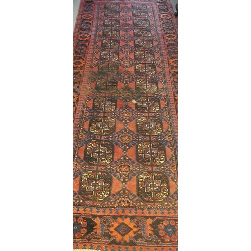 693 - Turkman runner on an orange ground with geometric and lozenge decoration inset with flowers and foli... 