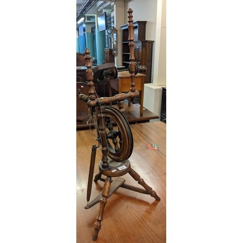 657 - Stained wooden upright travelling spinning wheel. 
(B.P. 21% + VAT)