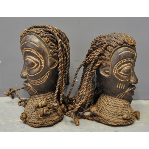 71 - Pair of African carved wooden heads, probably male and female, both with plaited rope hair and colla... 