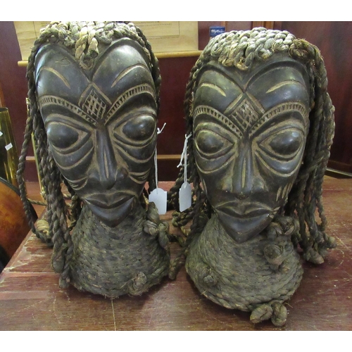 71 - Pair of African carved wooden heads, probably male and female, both with plaited rope hair and colla... 