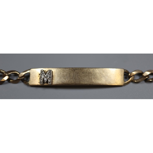 245 - 9ct gold identity bracelet decorated with a diamond set M.  Approx weight 11 grams.
(B.P. 21% + VAT)