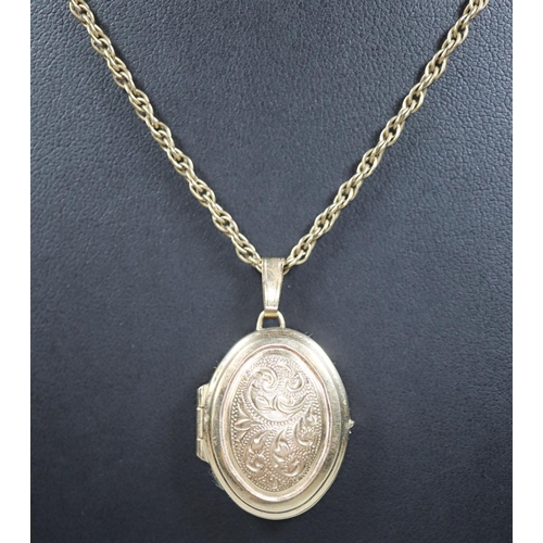 252 - 9ct gold oval engraved locket on a yellow metal chain.  Approx weight 10.8 grams.
(B.P. 21% + VAT)