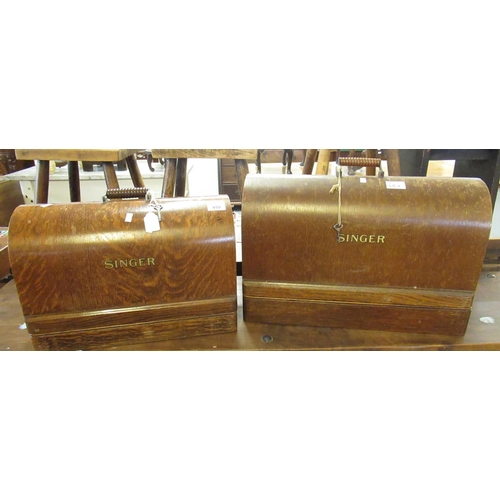 455 - Two similar vintage Singer sewing machines in oak bentwood cases and carrying handles. (2)
(B.P. 21%... 