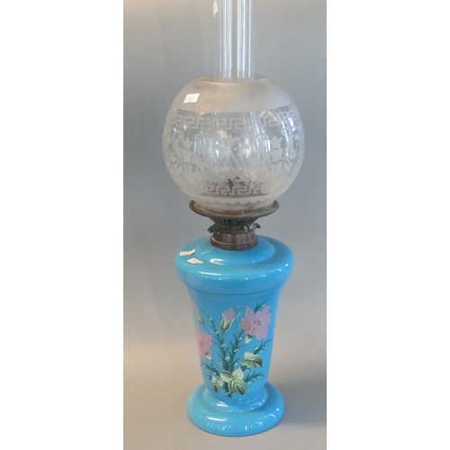 79 - Early 20th century double oil burner lamp with etched globular shade, above a blue opaline glass res... 