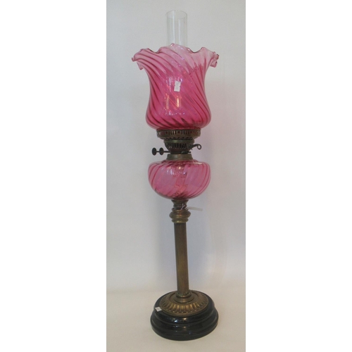 80 - Early 20th century double oil burner lamp with cranberry shade, cranberry reservoir standing on a br... 