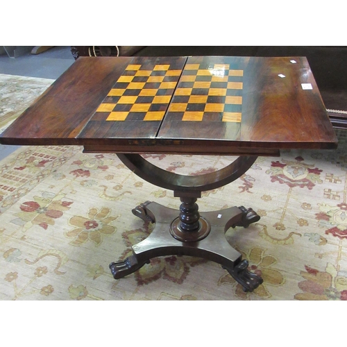 409 - 19th century rosewood folding games table, standing on a shaped and baluster turned pedestal and con... 