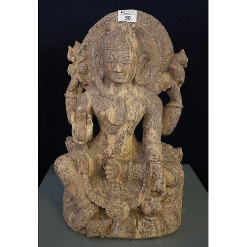 90 - Stone statue of a seated Shiva, here depicted with four arms, the raised left holding a small deer, ... 