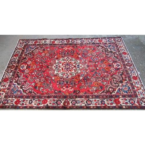 614 - Persian suruk full pile hand woven rug on a red ground with central medallion surrounded by flowers,... 