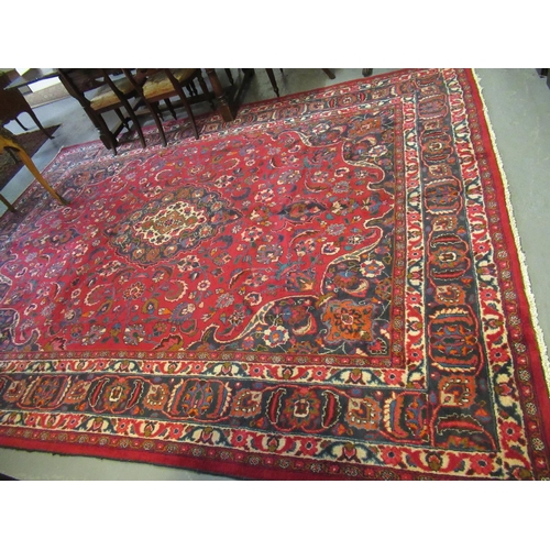 615 - Large red ground Persian Mashad carpet with floral medallion designs. 392 x 370cm approximately.
(B.... 