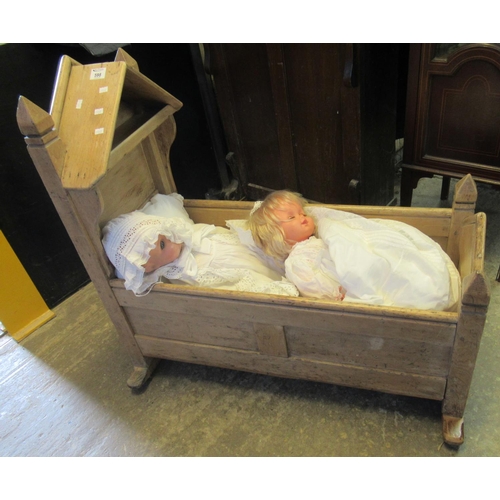 598 - 19th century stripped pine traditional child's canopied crib containing two modern large dolls,one c... 