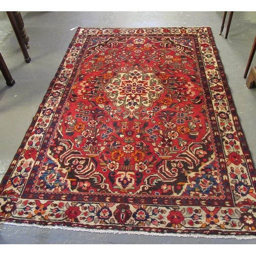 614 - Persian suruk full pile hand woven rug on a red ground with central medallion surrounded by flowers,... 