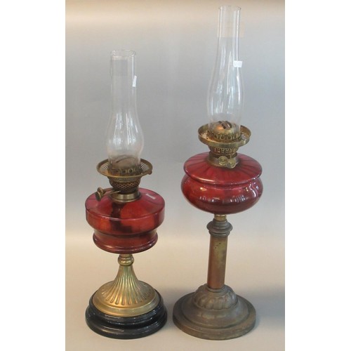 81A - Two similar early 20th century double oil burner lamps, both with cranberry reservoirs. (2)
(B.P. 21... 