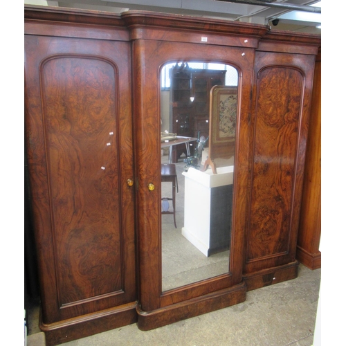 518 - A Victorian walnut breakfront 3 door wardrobe, the central door revealing shelves and an arrangement... 