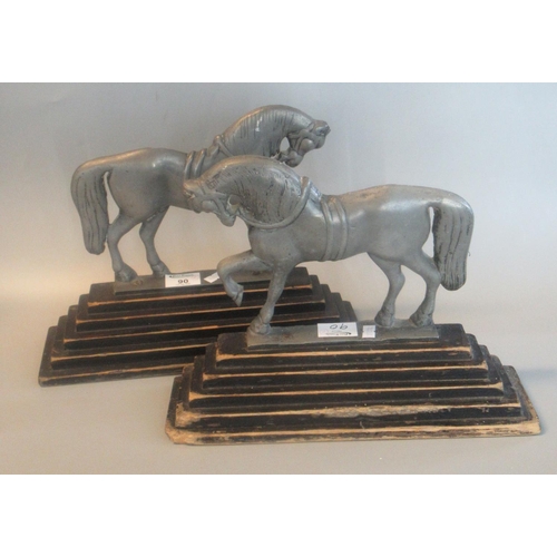 90 - Pair of white metal andirons/door stops in the form of horses on ebonised stepped wooden bases. 54cm... 