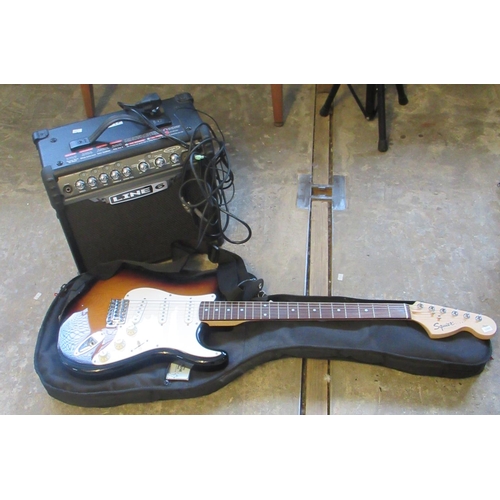 437 - Squire six-sting electric guitar in fabric case, together with a line six practice amplifier. (2)
(B... 