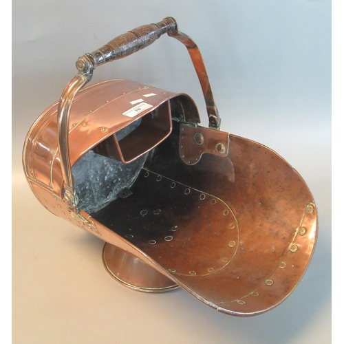 70 - Copper helmet shaped coal scuttle with turned wooden swing handle.
(B.P. 21% + VAT)