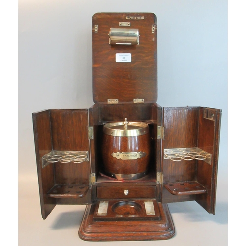 80 - Early 20th century oak cigar cabinet with silver plated mounts, the interior revealing a tobacco jar... 