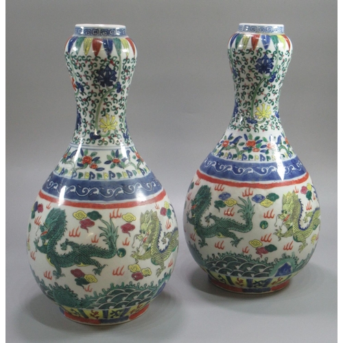 147 - Pair of Chinese porcelain baluster shaped vases with inverted garlick bulb  necks, overall decorated... 