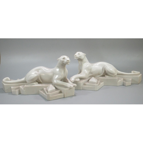 159 - After P. Trudeau, a pair of Art Deco style recumbent white panthers on geometric bases.  Signed.  (2... 