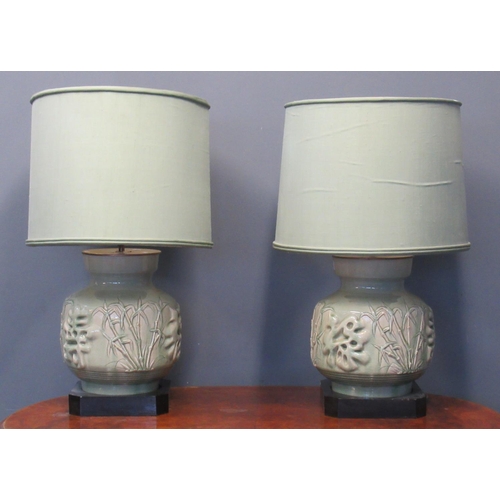 174 - Pair of celadon glazed oriental design table lamps of baluster form, with shades, the bodies decorat... 