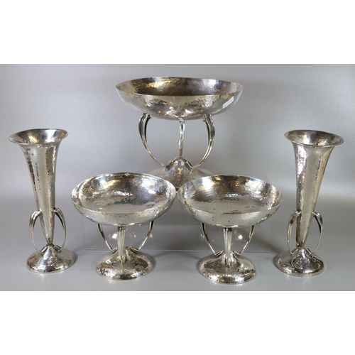 216 - An Arts and Crafts hammered silver bowl garniture set of one large and two small bowls on stylised s... 