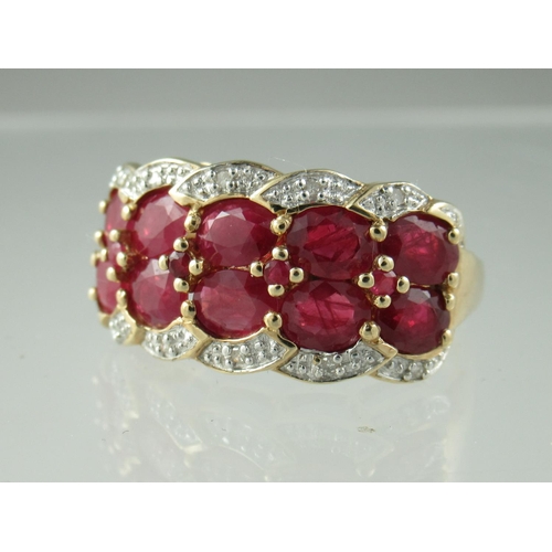 217 - A double row ruby ring, the ten oval cut rubies interspersed with smaller circular rubies and surrou... 