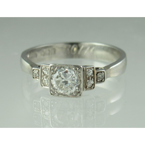 227 - Diamond solitaire ring with stepped diamond set shoulders set in platinum.  The central brilliant cu... 