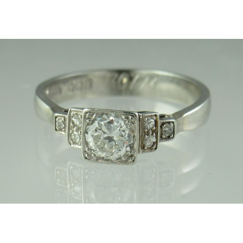 227 - Diamond solitaire ring with stepped diamond set shoulders set in platinum.  The central brilliant cu... 