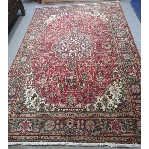 295 - Middle Eastern design red ground multicoloured carpet having central medallion of flowers and foliag... 