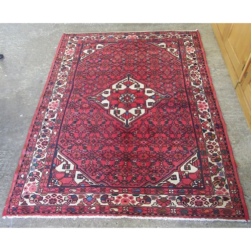 296 - Middle Eastern design red ground carpet with central floral medallion, the borders with stylised flo... 