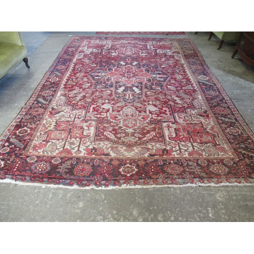 299 - Large Iranian carpet on a red on blue ground overall with stylised flowers and foliage and central m... 