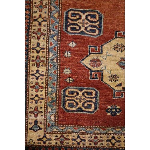 303 - 20th century Middle Eastern design carpet on a salmon ground with two central medallions having geom... 