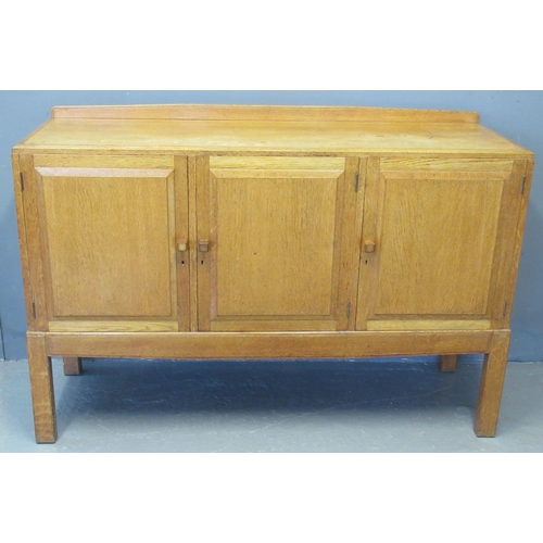 50 - In the style of Brynmawr, an oak sideboard having raised back panel above three blind panel fielded ... 