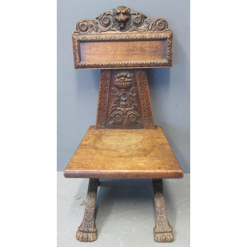 75 - Victorian carved oak hall chair, the carved back with flower head and lion mask head decoration abov... 