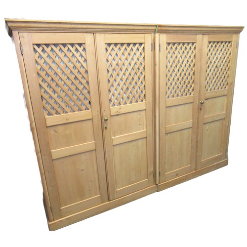 82 - Late 19th century pine four door wardrobe, the moulded cornice above four lattice panels having turn... 