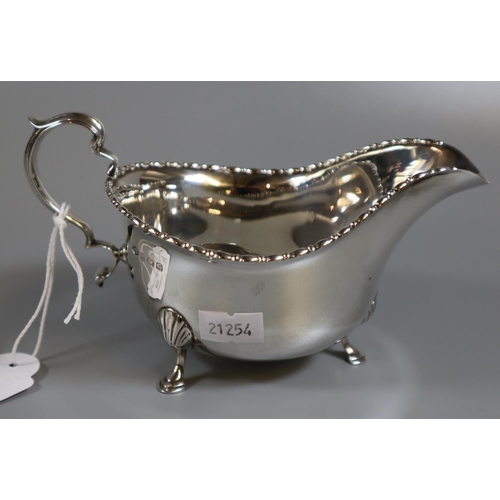 212 - A silver Georgian style sauce boat on shell cabriole legs and hoof feet, Birmingham hallmarks, 1930.... 