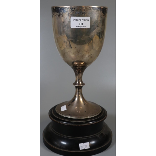 211 - Silver trophy cup on wooden ebonised socle base.  Sheffield hallmarks for Walker & Hall.  23cm high ... 