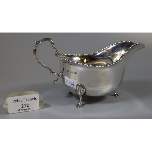 212 - A silver Georgian style sauce boat on shell cabriole legs and hoof feet, Birmingham hallmarks, 1930.... 