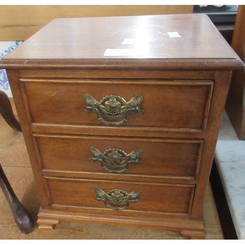 459 - An Edwardian design mahogany miniature table top straight front chest of three drawers on mounded br... 