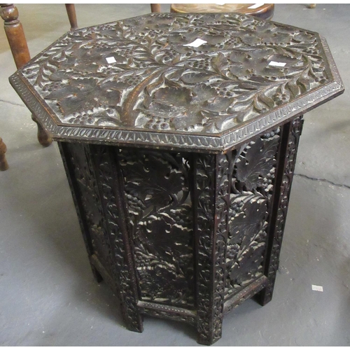 543 - Middle eastern design ornately carved octagonal folding campaign table.  (B.P. 21% + VAT)