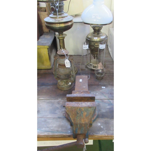 557 - Two oil burner lamps, one with opaline glass shade together with a vintage lantern and cast iron vic... 