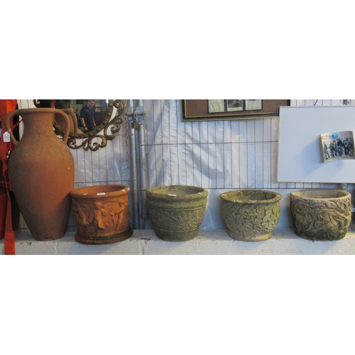 559 - Three composition stone garden pots with relief floral decoration, a terracotta garden pot with reli... 