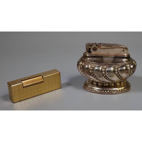 299 - Ronson silver plated table lighter, together with a vintage Dunhill gold plated Rollagas lighter. 
(... 