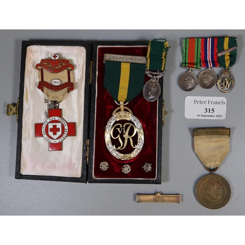 315 - A George VI Territorial medal dated 1951, a group of three dress miniatures to include; the same med... 